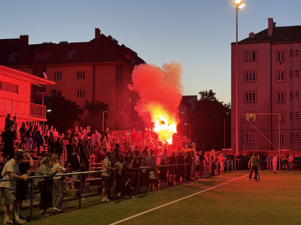 FavAC-Fans auf der Tribüne der Kennerroad im roten Licht