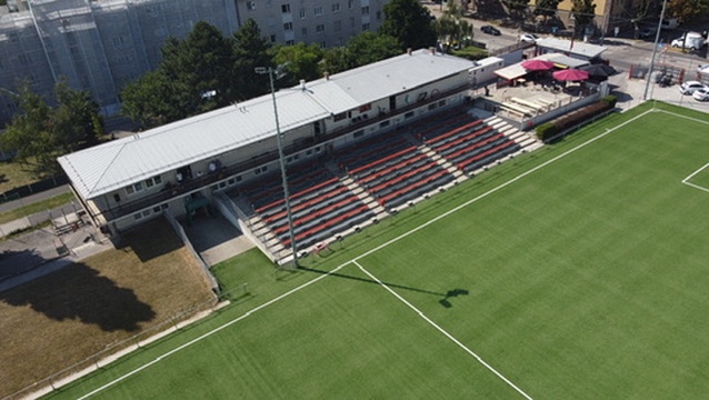 Blick von oben auf die rot-schwarze FavAC-Tribüne und das Spielfeld